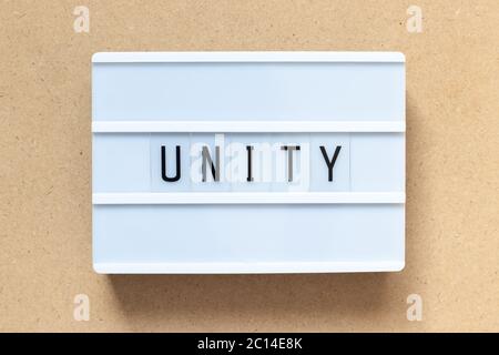 White lightbox with word unity on wood background Stock Photo