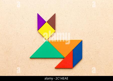 Color tangram puzzle in cat shape on wood background Stock Photo