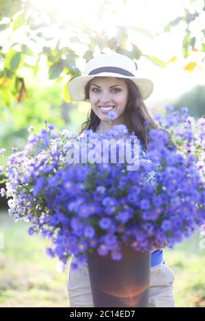 Woman florist with bouquet of flowers bucket outdoors Stock Photo