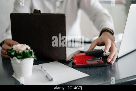 Businessman in home office holding stapler and documents isolated on white background. Professional using laptop and smart phone in the office Stock Photo