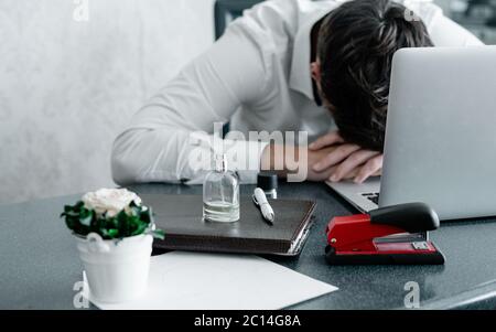 Businessman fallen asleep on her working desk with business book and stapler a notebook in front of he. Business and online shopping concept Stock Photo