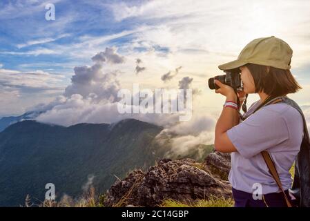 Hiker taking photo at sunset Stock Photo