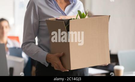 Close up businesswoman holding cardboard box with belongings Stock Photo