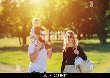 Happy family walking in countryside during beautiful sunny day outside Stock Photo