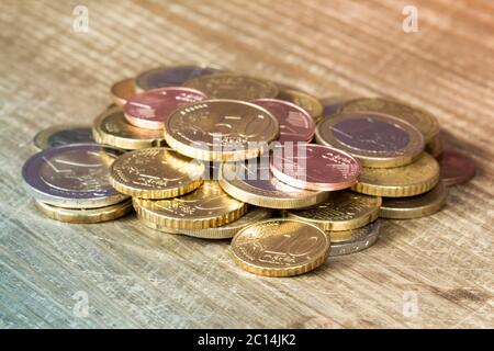 Euro coins piled on wooden table Stock Photo