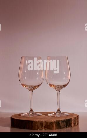 Two glasses of wine on white background, warm tone, wooden stump Stock Photo
