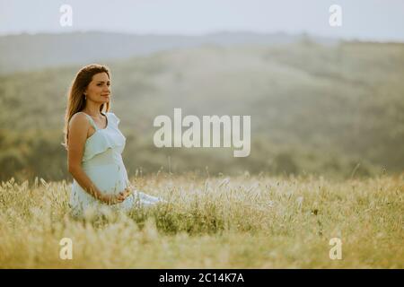 Young pregnant woman in white dress at the summer field Stock Photo - Alamy