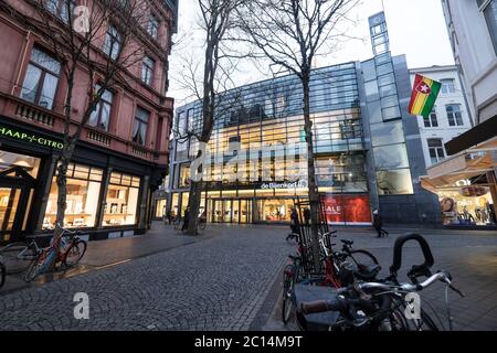 View of the department store 'De Bijenkorf' from the Maastrichter Brugstraat at the start of the evening with illuminated shop windows in Maastricht Stock Photo