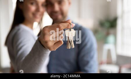 Close up happy young woman hugging man, holding keys Stock Photo