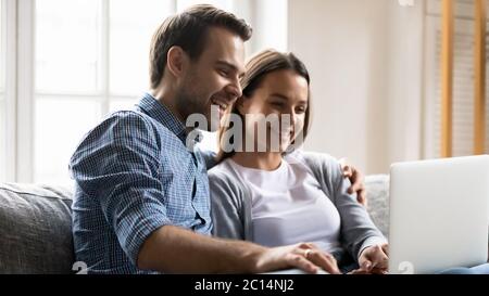 Happy young couple having fun with laptop together Stock Photo
