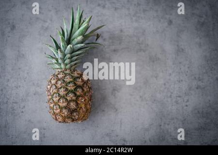 Fresh pineapple on table against grey wall. Ripe pineapple Clipping Path. Concept with copyspace. Stock Photo
