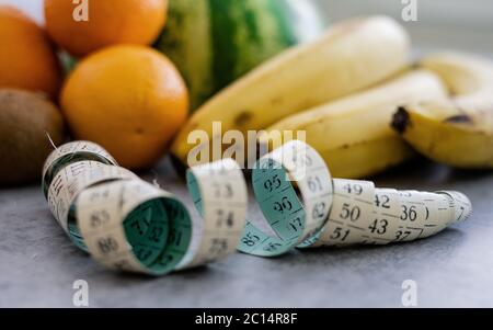Fresh fruit measure tape and multivitamin juice isolated on white background. Healthy sport and diet concept. Stock Photo