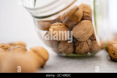 Glass jar filled with healthy walnut kernels whole walnuts.The perfect health fat and good carbohydrate to provide nutrition! Vintage bowl. Stock Photo