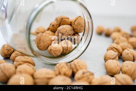 Glass jar filled with healthy walnut kernels whole walnuts.The perfect health fat and good carbohydrate to provide nutrition! Vintage bowl. Stock Photo