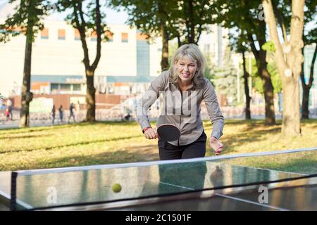 Business woman playing ping pong table tennis in the park Stock Photo