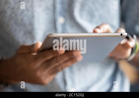 Close up hands of African man holding digital tablet device Stock Photo