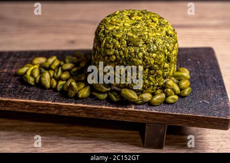 Goat cheese balls wrapped with pistachio. Cheese on black background. Traditional dinner. High quality photo Stock Photo