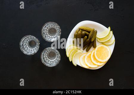 Three glasses of vodka and snack gherkins, lemon, lime Stock Photo