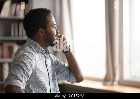 African businessman holding mobile phone talking solving issues distantly Stock Photo