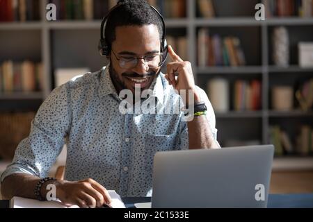 African man wear headset watching webinar video course Stock Photo