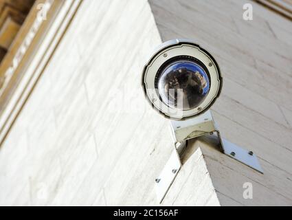 security CCTV camera or surveillance system fixed on old construction wall Stock Photo