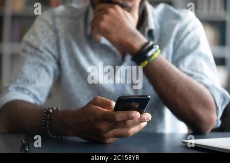 African guy holding smartphone closeup view hands and device Stock Photo