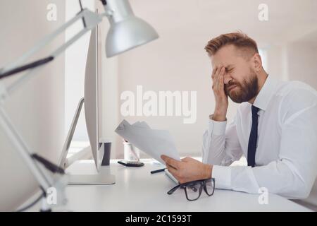 A lot of work in the office. Tired busy businessman is working with computer. Stock Photo