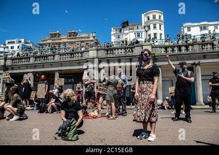 Brighton, UK. 13th June, 2020. Young people are seen on the seafront during the BLM silent protest in Brighton.Local activists in England organised a protest in the centre of Brighton in solidarity with the BLM protesters in the US to highlight the systemic racism and police brutality in the UK. Credit: SOPA Images Limited/Alamy Live News Stock Photo