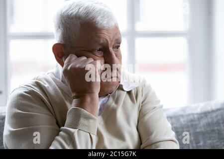 Close up sad lonely mature man lost in thoughts Stock Photo