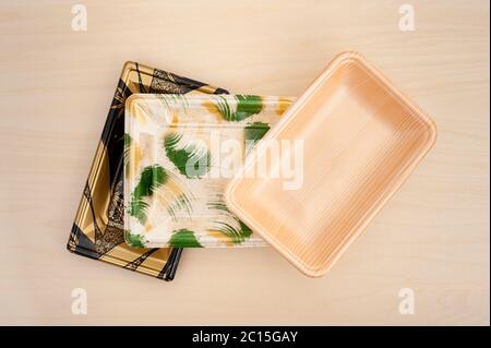 Colorful foam food container trays (Styrofoam trays) stacked. Isolated on  wood background. Close-up. Horizontal shot Stock Photo - Alamy