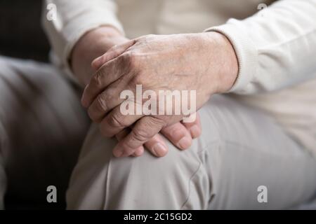 Close up elderly lonely man folded hands on lap Stock Photo