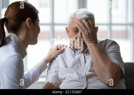 Female doctor comforting older man patient feeling unwell Stock Photo