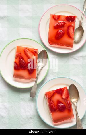 Sponge cake with yoghurt and lemon layers with strawberries and jelly Stock Photo