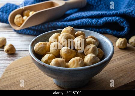 Macadamia nuts in modern bowl on table. Macadamia nuts are a source of protein packed with healthy vitamins. Stock Photo