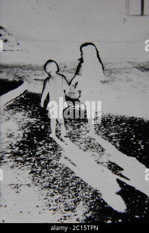 Fine 70s vintage black and white extreme photography of two girls walking away from the camera. Stock Photo