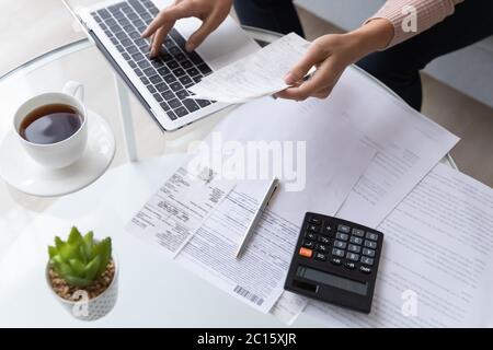 Top view close up woman calculating bills, using laptop Stock Photo