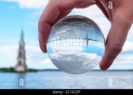 Glass ball with reflection: Kalyazin flooded Belfry or bell tower over Volga river is a part of the flooded old church in old Russian town Kalyazin Stock Photo
