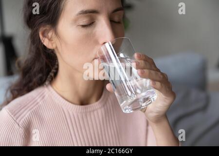 Close up beautiful young woman drinking pure mineral water Stock Photo