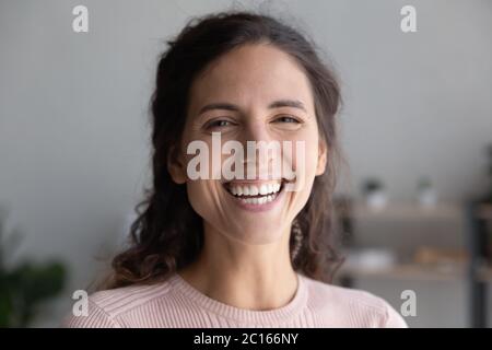 Head shot portrait laughing overjoyed beautiful woman looking at camera Stock Photo