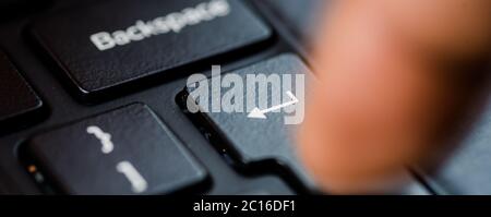 Enter key pressed by a finger on keyboard Stock Photo