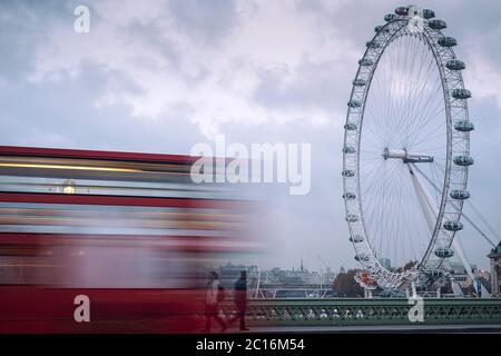 Double decker bus driving by the London Eye in London, England, UK