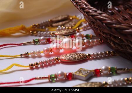 Indian festival: Raksha Bandhan background with an elegant Rakhi, Rice Grains and Kumkum. A traditional Indian wrist band which is a symbol of love Stock Photo