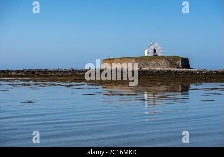 St Cwyfan's medieval church in Llangadwaladr, Anglesey, Wales. Located on the small tidal island of Cribinau, it's known as the Church in the Sea. Stock Photo