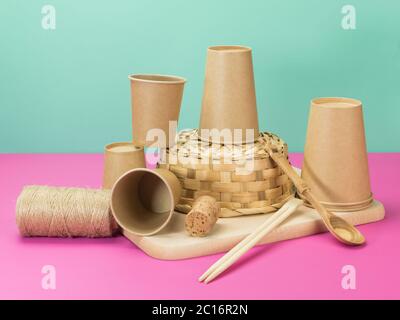 Environmental crockery and other household items from natural materials. Beige pink and turquoise background. Stock Photo