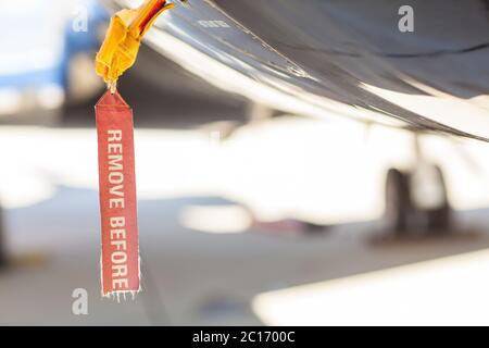 Red old seedy Remove Before Flight Tag on an airplane fuselage Stock Photo