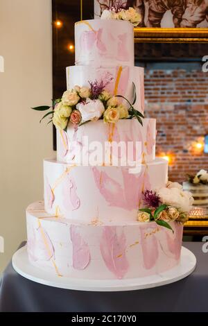 Five layered wedding cream cake decorated with flowers Stock Photo