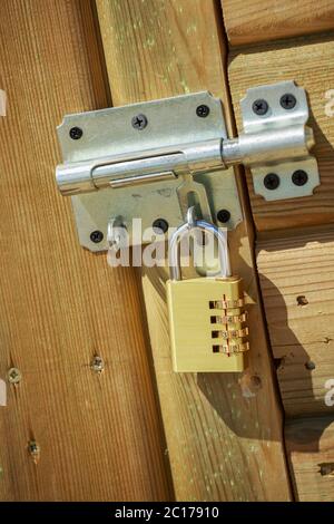 Steel gold padlock on wooden door Stock Photo