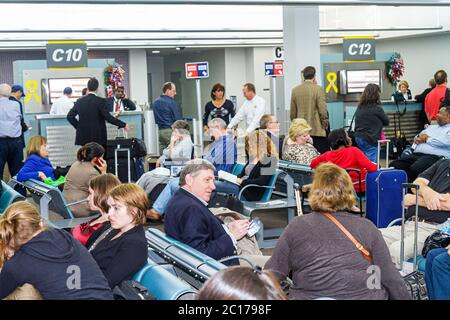 New Orleans Louisiana,Louis Armstrong New Orleans International Airport,MSY,terminal,gate,passenger passengers rider riders,waiting area,sitting,man m Stock Photo