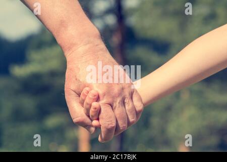 Hands of young child and old senior Stock Photo