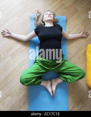 Middle aged woman doing yoga indoors Stock Photo